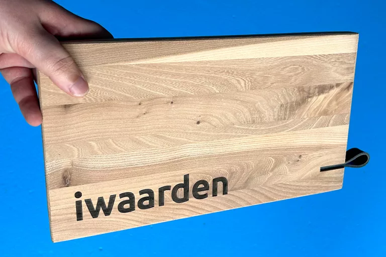 Een snijplank van echt Zeeuws Hout, gegraveerd met logo